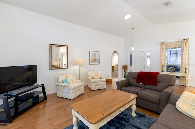 living room featuring wood-type flooring and lofted ceiling