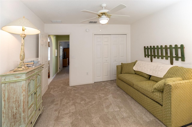 carpeted living room with ceiling fan