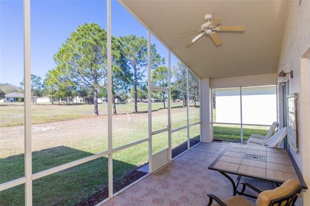 unfurnished sunroom with ceiling fan and a healthy amount of sunlight