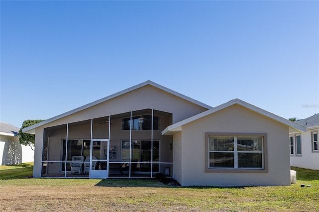 rear view of house with a lawn and a sunroom