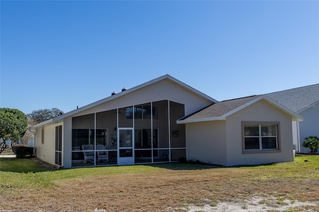 rear view of property featuring a sunroom and a yard