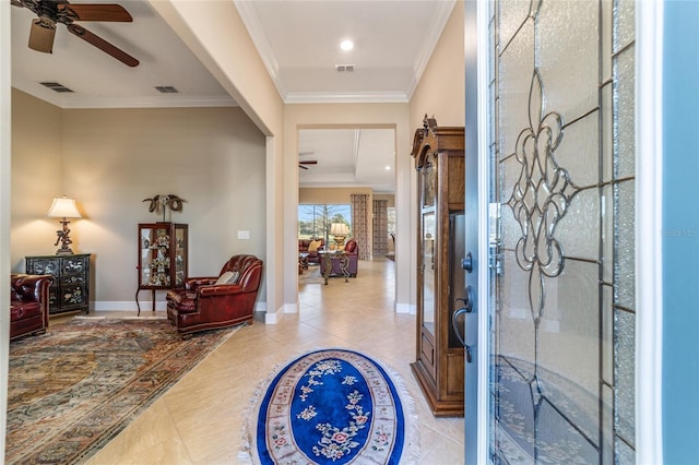 foyer featuring ceiling fan, ornamental molding, and light tile patterned flooring