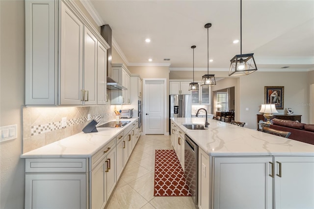 kitchen with light stone counters, sink, a spacious island, and decorative light fixtures