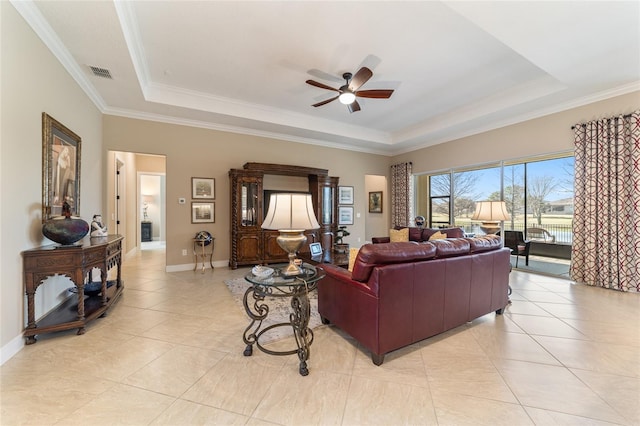 tiled living room featuring a tray ceiling, ceiling fan, and crown molding