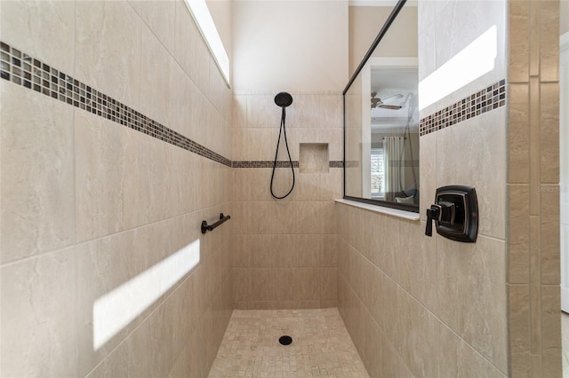 bathroom with ceiling fan and a tile shower