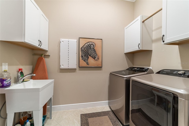 clothes washing area featuring light tile patterned flooring, cabinets, and washing machine and dryer