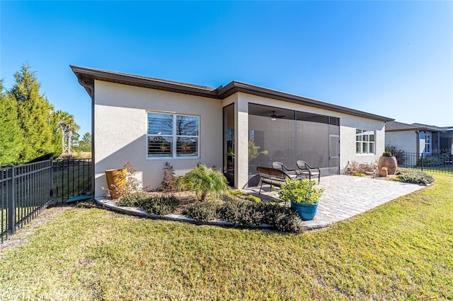 rear view of property with a yard, a patio, ceiling fan, and a sunroom