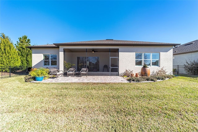 rear view of property with a yard, ceiling fan, and a patio area