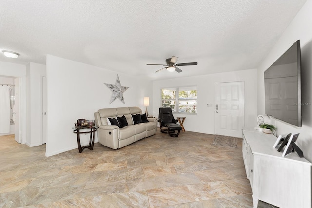 living room with ceiling fan and a textured ceiling