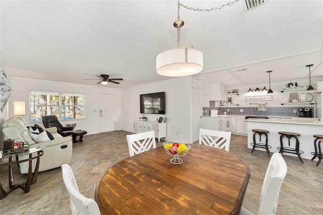 dining room with ceiling fan and a textured ceiling