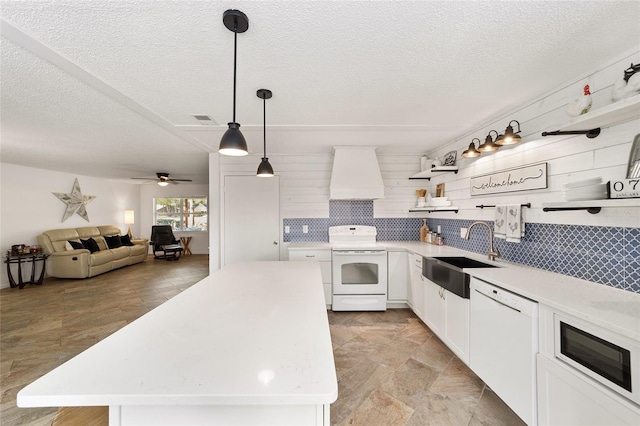 kitchen featuring sink, a center island, white appliances, and custom exhaust hood