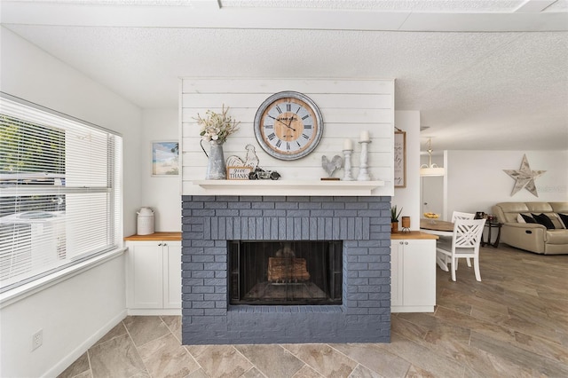 unfurnished living room with a textured ceiling, a fireplace, and a wealth of natural light