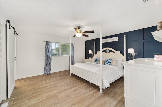 bedroom with a barn door and ceiling fan