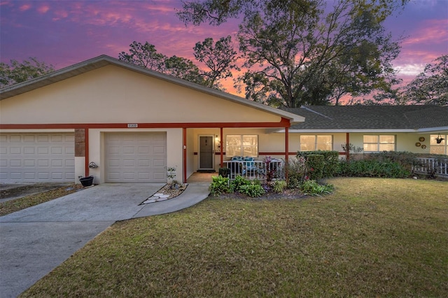 single story home with a yard, a porch, and a garage