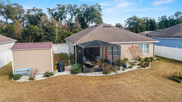 rear view of house with a lawn, glass enclosure, and a shed