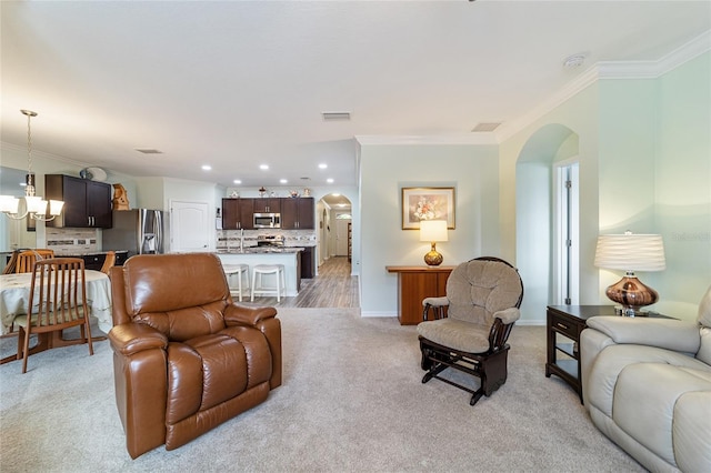 living room featuring light carpet, crown molding, and sink