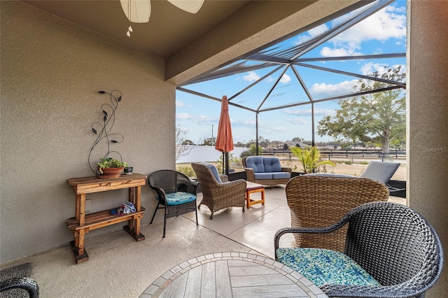 view of patio / terrace featuring an outdoor living space, ceiling fan, and a lanai