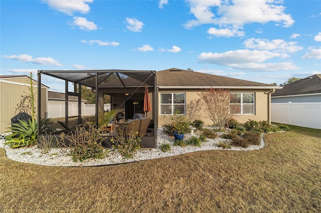 back of property with a yard and a lanai