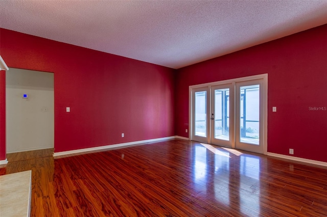 spare room featuring french doors, a textured ceiling, and hardwood / wood-style flooring