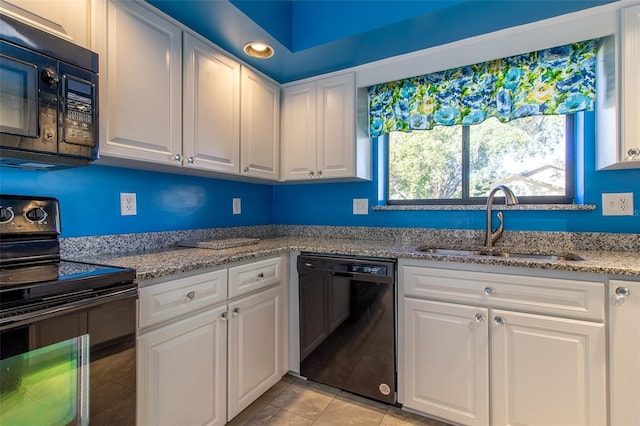 kitchen featuring black appliances, white cabinets, light tile patterned floors, and sink