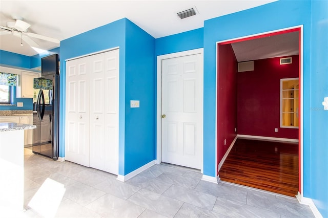 unfurnished bedroom with ceiling fan and black fridge