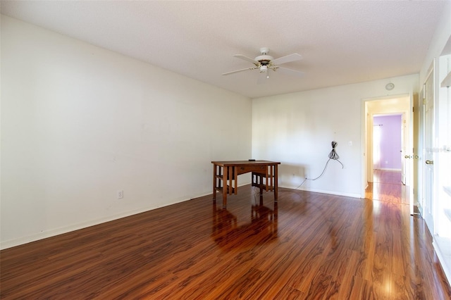 unfurnished room with ceiling fan and dark wood-type flooring