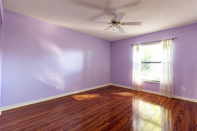 empty room with a textured ceiling, ceiling fan, and dark wood-type flooring