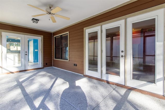 unfurnished sunroom with ceiling fan and french doors