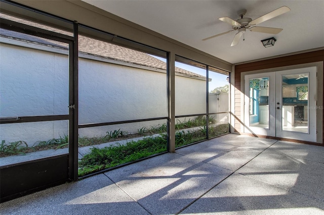 unfurnished sunroom featuring ceiling fan and french doors