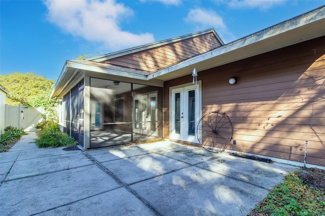 back of property featuring a sunroom, a patio, and french doors