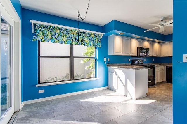 kitchen featuring baseboards, a peninsula, black appliances, and ceiling fan with notable chandelier