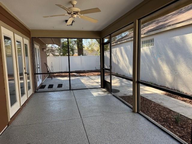 unfurnished sunroom with a ceiling fan