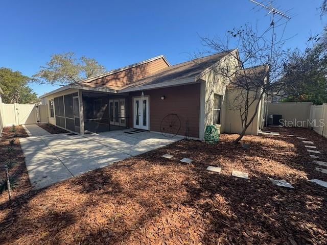 exterior space with french doors, a patio area, a fenced backyard, and a gate