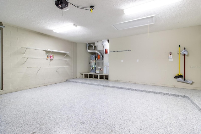 garage with heating unit, a garage door opener, gas water heater, and concrete block wall