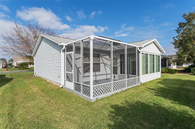 back of house with a lanai and a yard