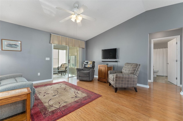 living room featuring light wood-type flooring, vaulted ceiling, and ceiling fan