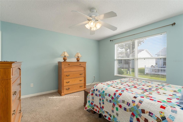 bedroom with a textured ceiling, ceiling fan, and light carpet