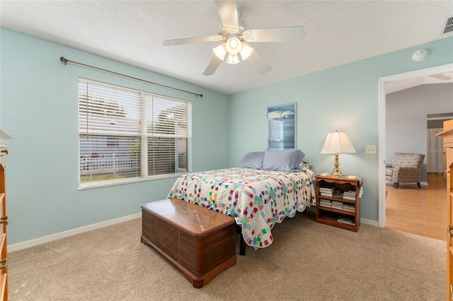 carpeted bedroom with ceiling fan and a textured ceiling