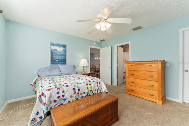 carpeted bedroom with ceiling fan and a textured ceiling