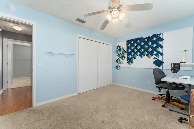 office area with ceiling fan, carpet, and a textured ceiling