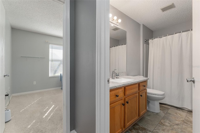 bathroom featuring vanity, a textured ceiling, and toilet