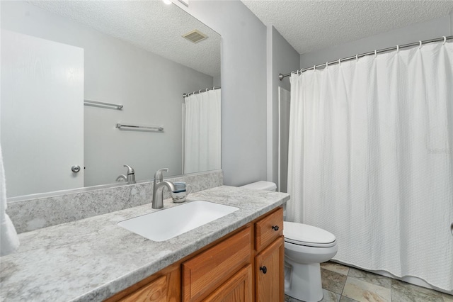 bathroom featuring vanity, toilet, and a textured ceiling