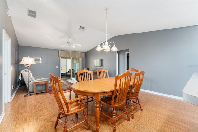 dining room with ceiling fan with notable chandelier, light hardwood / wood-style floors, and lofted ceiling