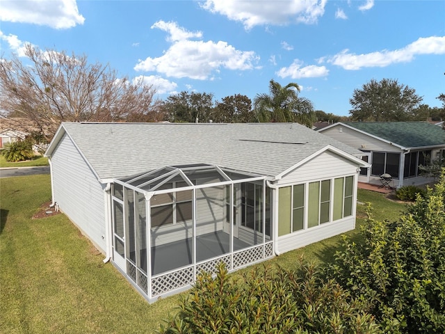 rear view of property featuring a lanai and a lawn