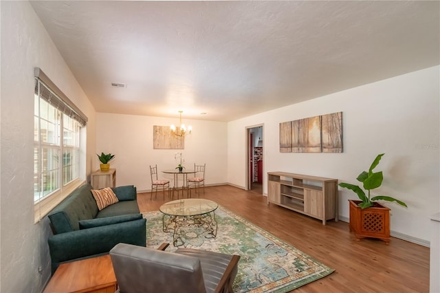 living room featuring hardwood / wood-style flooring and an inviting chandelier