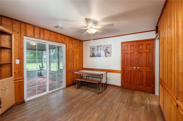 doorway to outside featuring ceiling fan, crown molding, and wood-type flooring