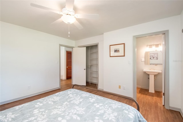 unfurnished bedroom featuring ceiling fan, sink, light hardwood / wood-style flooring, connected bathroom, and a closet