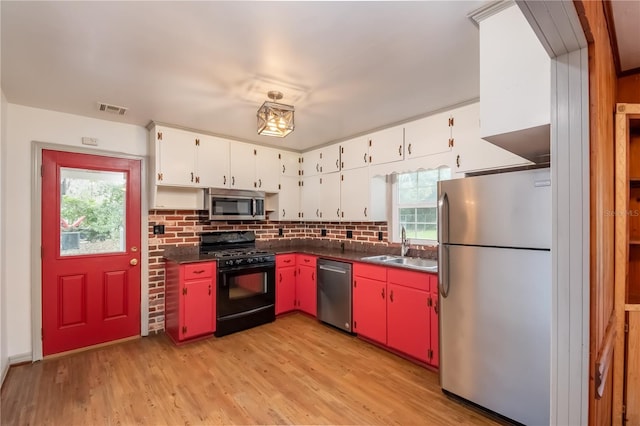 kitchen with sink, light hardwood / wood-style flooring, appliances with stainless steel finishes, a healthy amount of sunlight, and white cabinetry