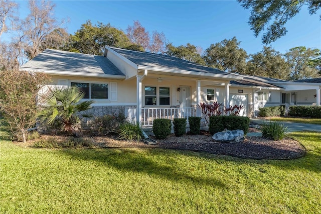 ranch-style house featuring covered porch, a garage, and a front lawn