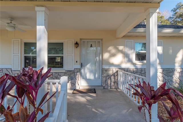 view of exterior entry with ceiling fan and covered porch